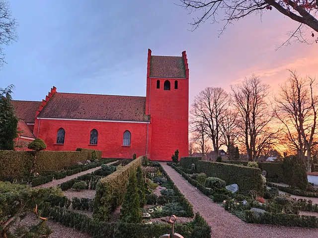 En gruppe kvinder og en præst står samlet foran alteret i en lys kirke.