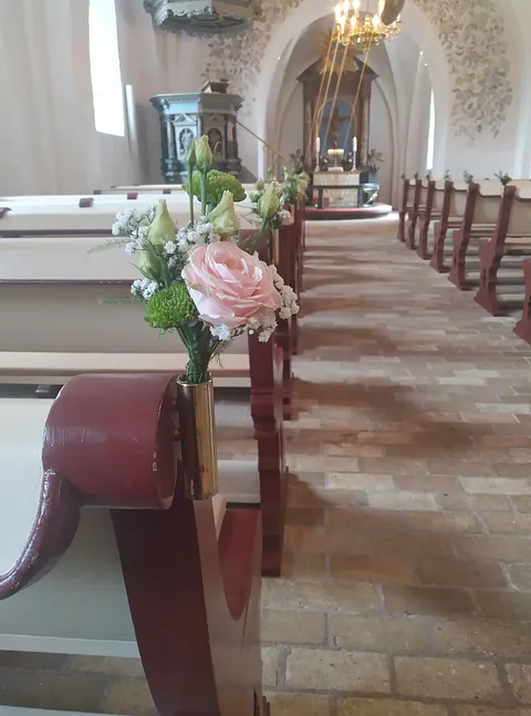 Lyserød rose pyntet op til fest i kirken.